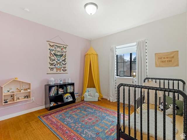 bedroom featuring baseboards and wood finished floors