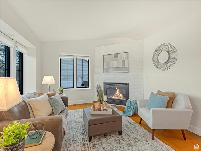 living room with lofted ceiling, wood finished floors, and a fireplace