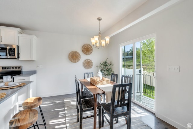 dining room with dark wood-type flooring, baseboards, and a chandelier