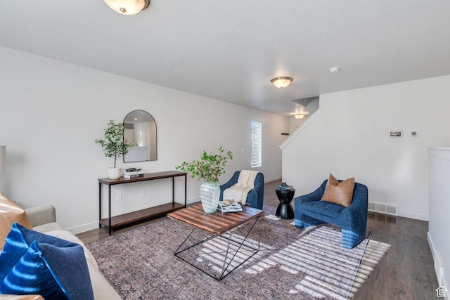 living area featuring wood finished floors, visible vents, and baseboards