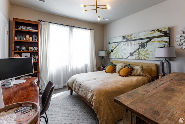 carpeted bedroom featuring a notable chandelier and visible vents