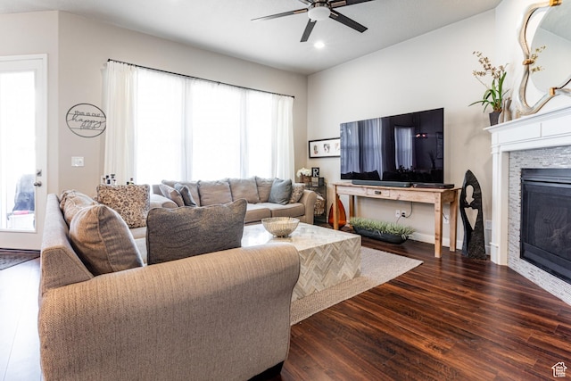 living area featuring baseboards, recessed lighting, wood finished floors, ceiling fan, and a fireplace