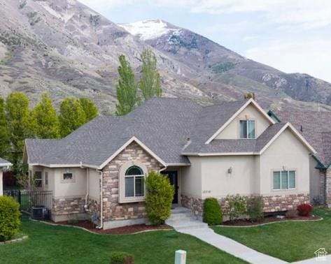 10716 N Hayes Cir, Cedar Hills, UT 84062 - view of front of house featuring a mountain view, stucco siding, a front yard, and stone siding