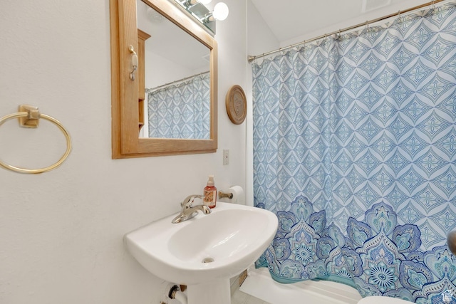 bathroom with a shower with shower curtain, visible vents, and a sink