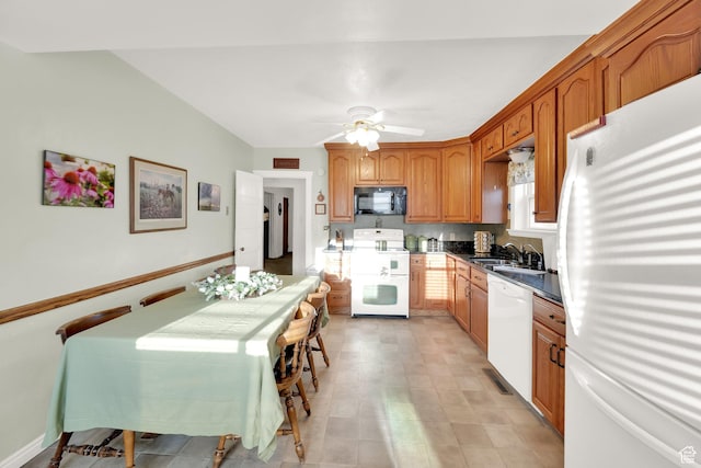 kitchen featuring a ceiling fan, dark countertops, a sink, brown cabinets, and white appliances