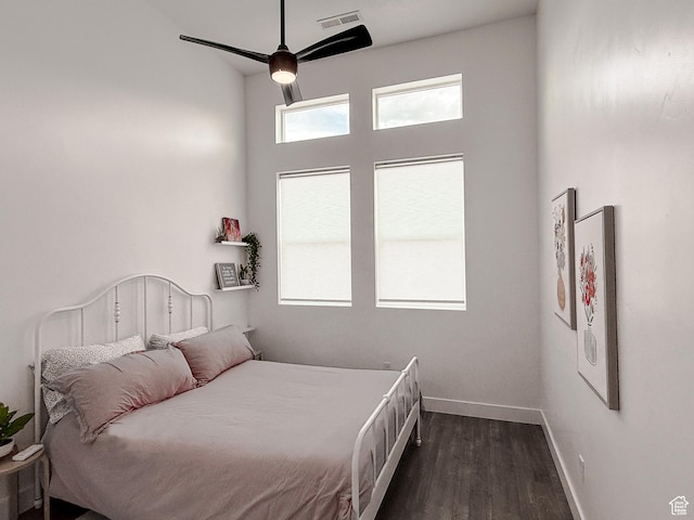 bedroom with baseboards, visible vents, dark wood-type flooring, and ceiling fan
