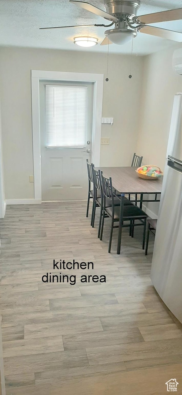 338 E 100 N, Moab, UT 84532 - dining space featuring a wall mounted air conditioner, ceiling fan, baseboards, and light wood-style floors
