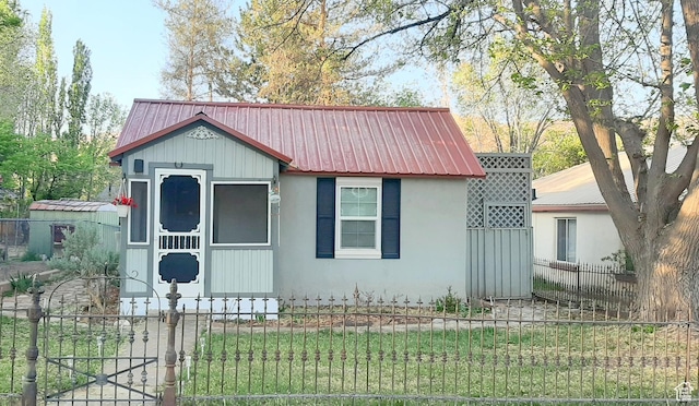 bungalow-style house featuring a gate, a fenced front yard, and metal roof