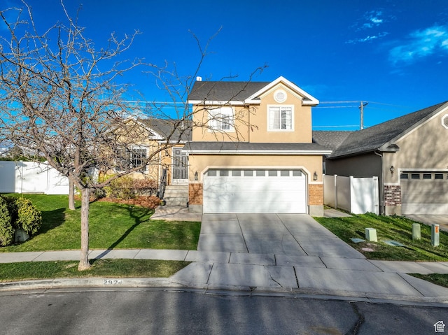traditional home featuring a front lawn, concrete driveway, fence, an attached garage, and stucco siding