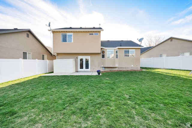 back of property featuring a fenced backyard, stucco siding, french doors, a patio, and a lawn