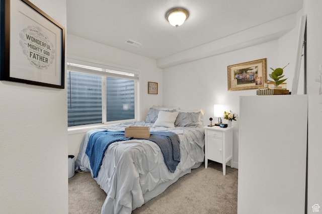 carpeted bedroom featuring visible vents