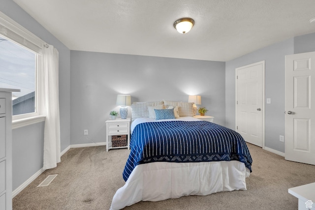 carpeted bedroom featuring baseboards and visible vents