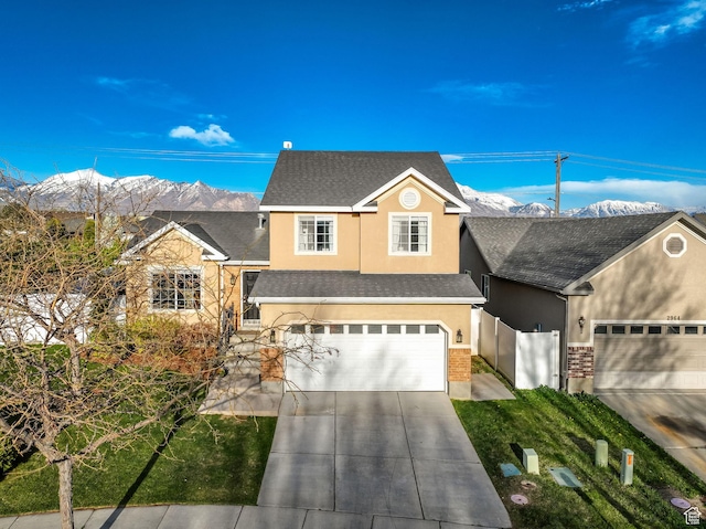 view of front of house featuring fence, a shingled roof, concrete driveway, an attached garage, and stucco siding
