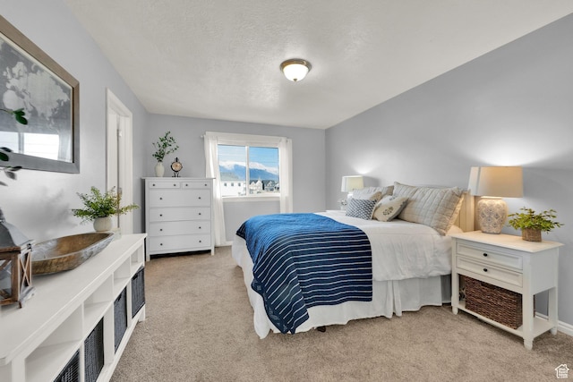 bedroom with light carpet and a textured ceiling