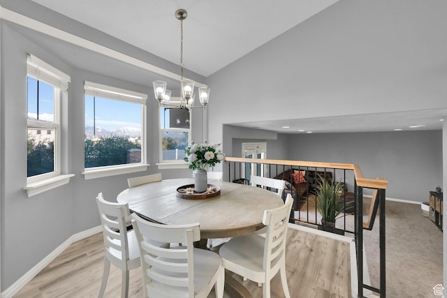 dining space featuring high vaulted ceiling, baseboards, a notable chandelier, and light wood-type flooring