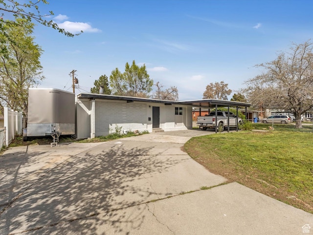 view of front facade featuring a front lawn, driveway, a carport, fence, and brick siding