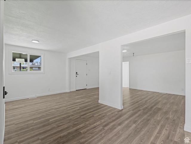 below grade area featuring baseboards, wood finished floors, and a textured ceiling
