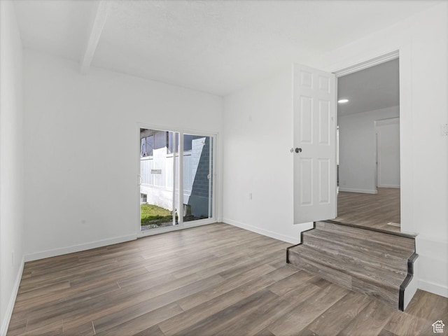 unfurnished room with baseboards and wood finished floors