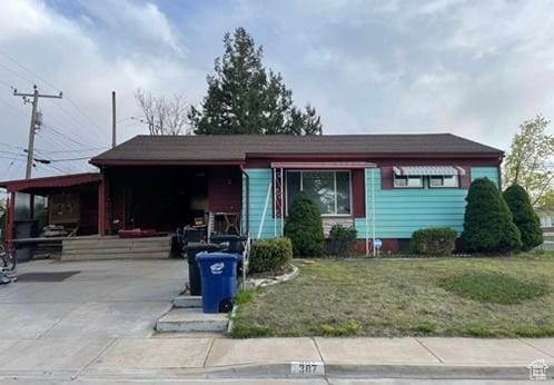single story home featuring a front yard and concrete driveway