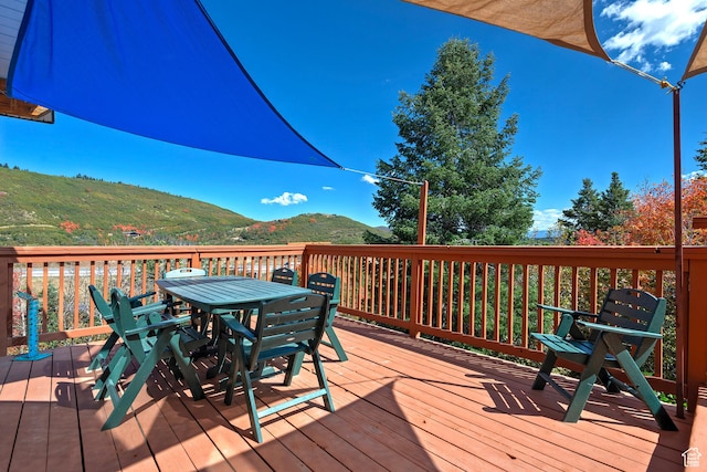 wooden terrace featuring outdoor dining area and a mountain view