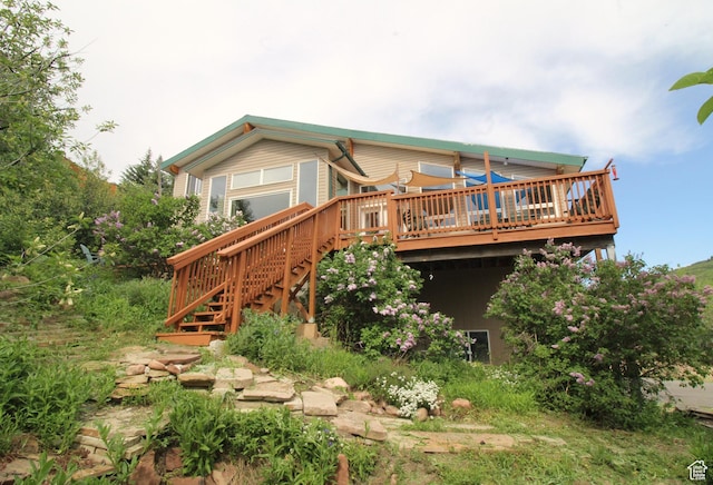 rear view of property with a wooden deck and stairs
