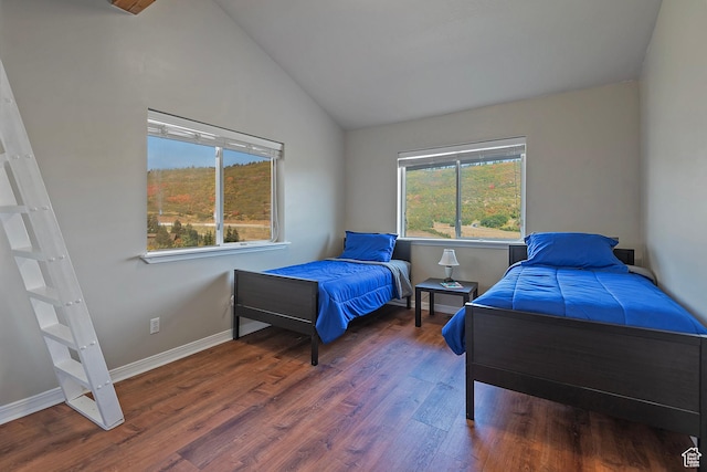 bedroom with lofted ceiling, baseboards, and wood finished floors