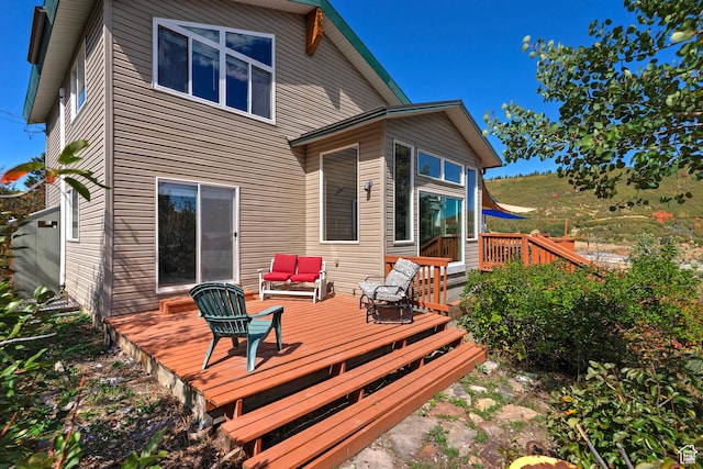 rear view of house with outdoor lounge area and a deck
