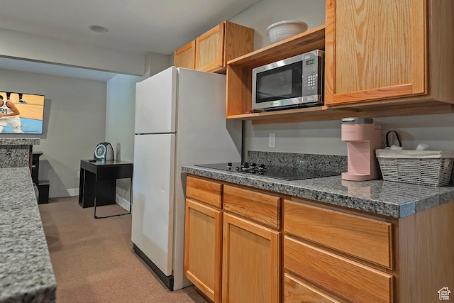 kitchen featuring open shelves, black electric stovetop, light colored carpet, stainless steel microwave, and freestanding refrigerator