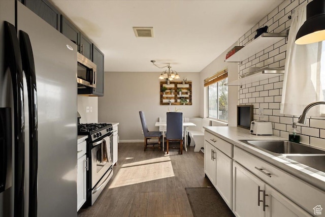 781 N 950 W, Orem, UT 84057 - kitchen featuring open shelves, appliances with stainless steel finishes, light countertops, dark wood-style flooring, and visible vents