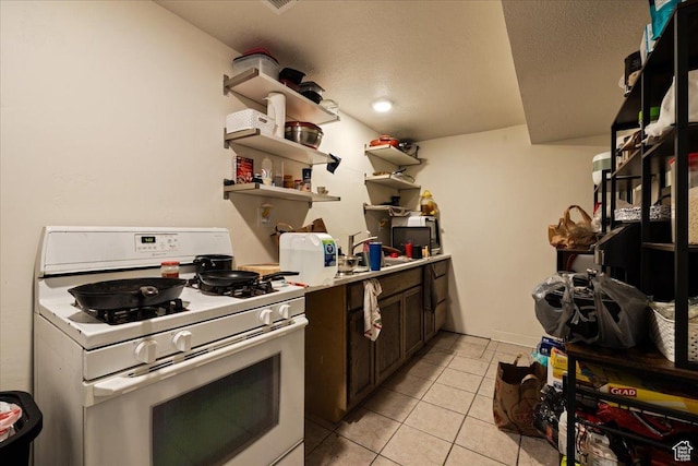 781 N 950 W, Orem, UT 84057 - kitchen with open shelves, dark brown cabinets, white range with gas stovetop, light tile patterned flooring, and light countertops