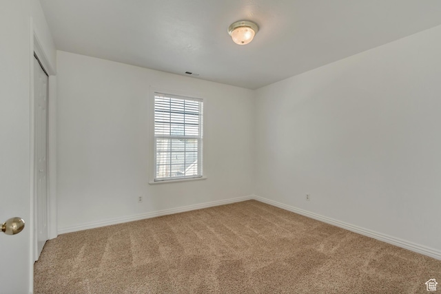 carpeted empty room featuring visible vents and baseboards