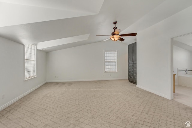unfurnished living room featuring baseboards, lofted ceiling, a ceiling fan, and light carpet