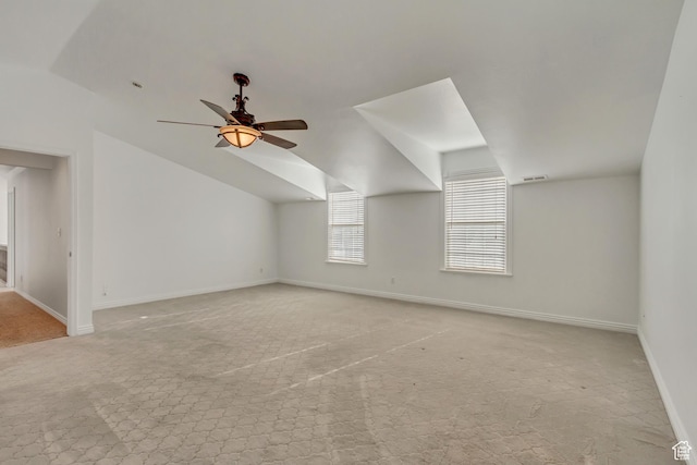 bonus room with ceiling fan, baseboards, light colored carpet, lofted ceiling, and visible vents