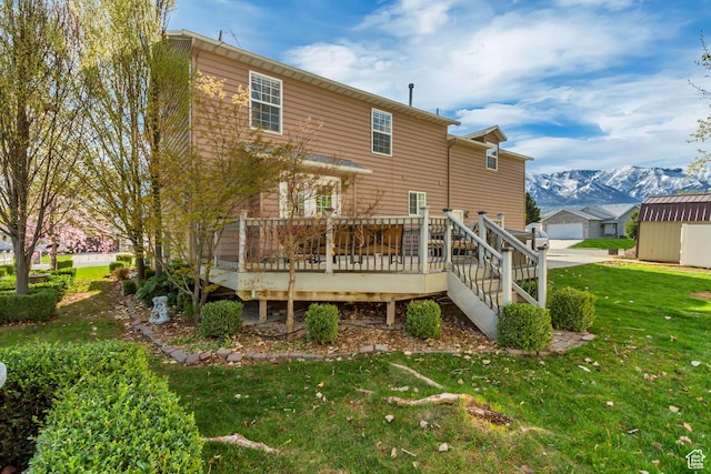 back of property featuring an outdoor structure, a yard, and a deck with mountain view