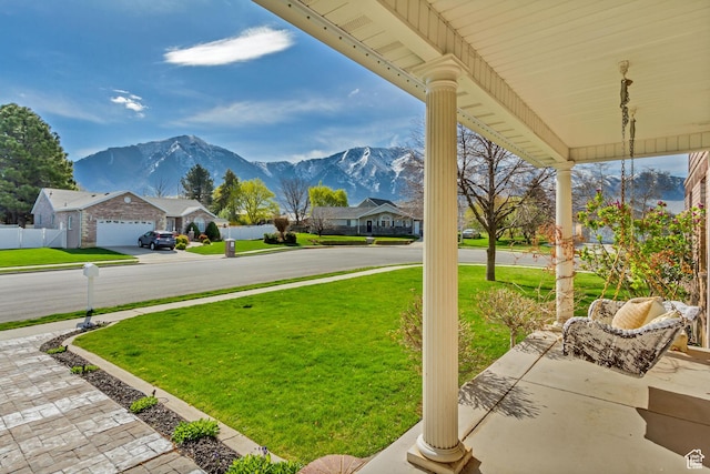view of yard with fence, a residential view, and a mountain view