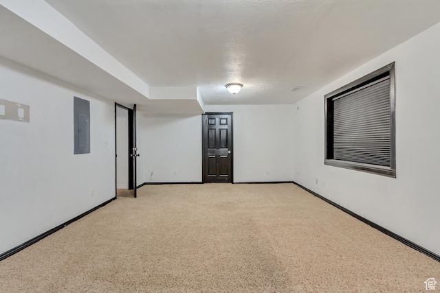 unfurnished room featuring baseboards, electric panel, and light carpet
