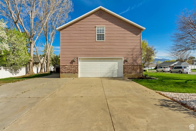 view of side of property featuring an attached garage, driveway, brick siding, and a yard