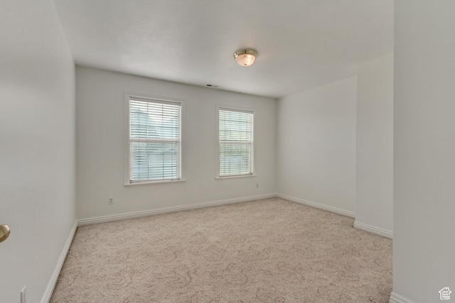 spare room featuring visible vents, baseboards, and carpet