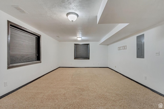 carpeted spare room with electric panel, baseboards, and visible vents