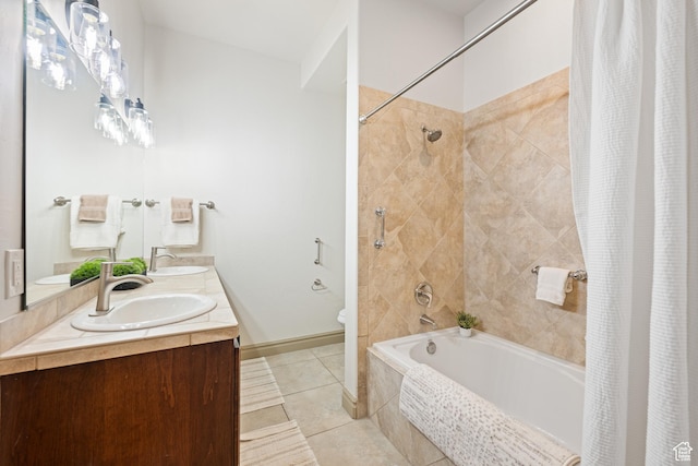 full bathroom with tile patterned flooring, a sink, tiled shower / bath combo, and toilet