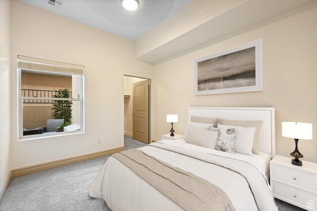 bedroom featuring a walk in closet, carpet, visible vents, and baseboards