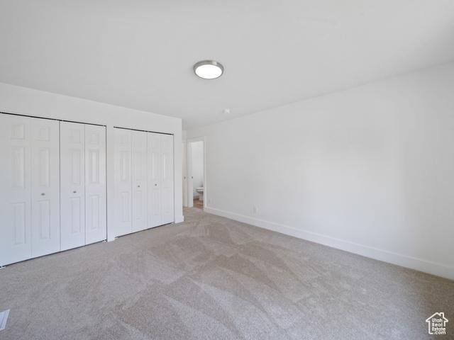 704 W Daisy Ln S, Murray, UT 84123 - unfurnished bedroom featuring multiple closets, baseboards, and carpet