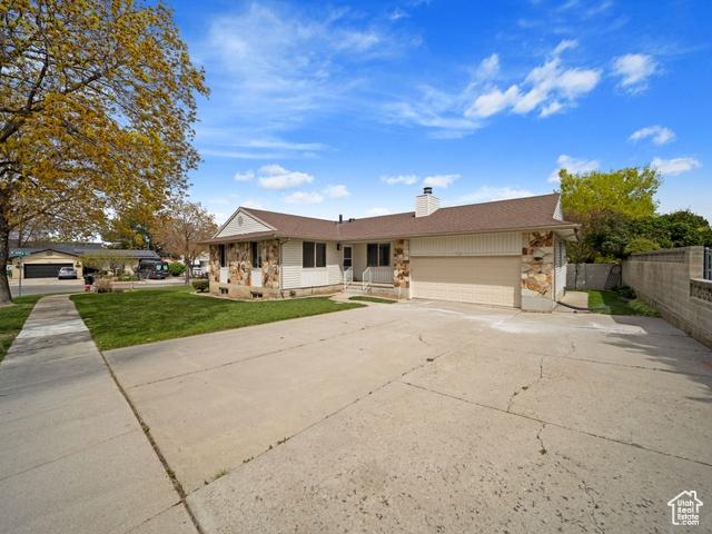 704 W Daisy Ln S, Murray, UT 84123 - ranch-style home with a chimney, fence, concrete driveway, a front yard, and a garage