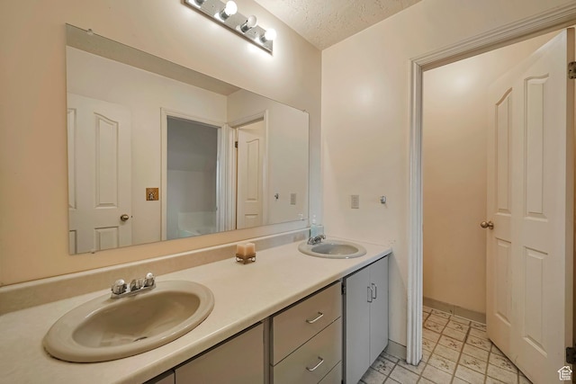 bathroom featuring double vanity, a textured ceiling, and a sink