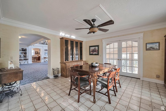 dining space with ceiling fan, arched walkways, ornamental molding, and french doors
