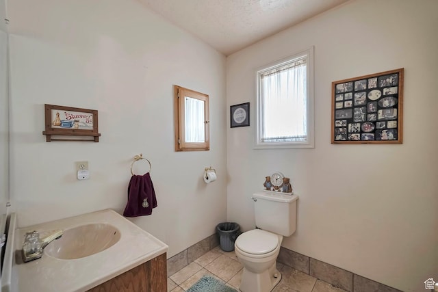 bathroom with tile patterned floors, baseboards, vanity, and toilet
