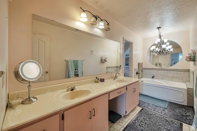 full bath with a bath, an inviting chandelier, a sink, and a textured ceiling