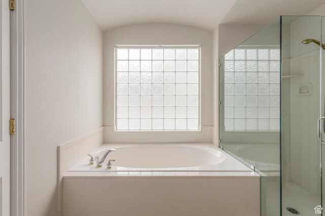 bathroom featuring a garden tub, a wealth of natural light, and a shower stall