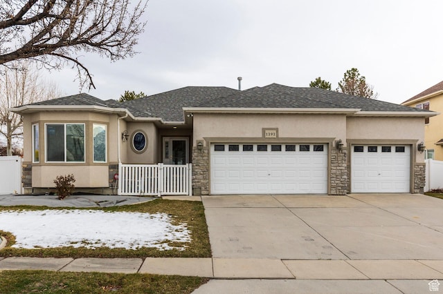 ranch-style house with stucco siding, an attached garage, driveway, and stone siding