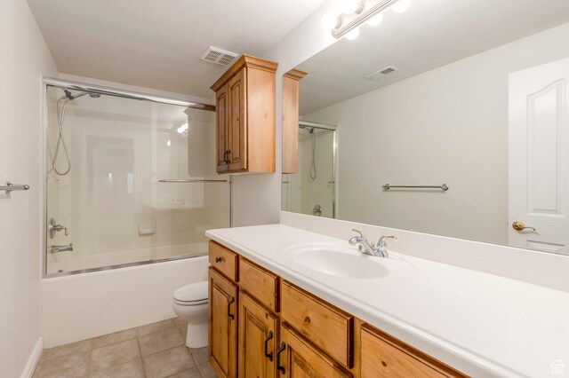bathroom featuring shower / bath combination with glass door, toilet, vanity, and visible vents
